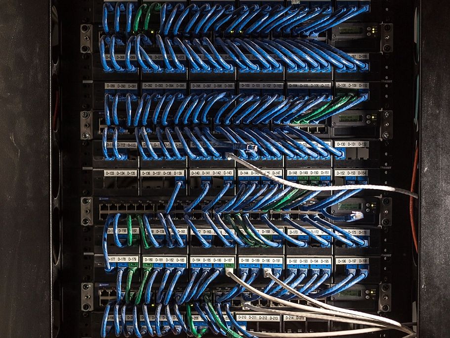 Panel krosowy z opisanymi portami i niebieskimi kablami sieciowymi